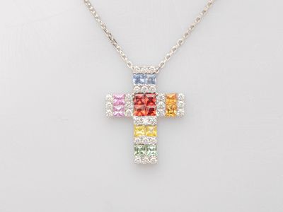 un pendentif en forme de croix multicolore muni d'une chaîne, sur fond blanc