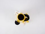overhead view of a yellow and black coffee cup on a white surface