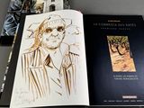 two books on a table with a drawing of a man in a hat