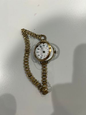 une image représentant une montre de couleur dorée entourée d'une chaîne