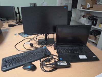 a desk with two computers and a keyboard on it