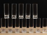 several shot glasses are lined up on a table with a black background