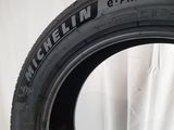 a close up of a tire on a white surface with a white curtain in the background