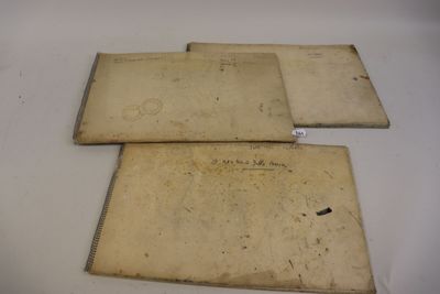 Deux vieux livres sont posés sur une table, avec des étiquettes dessus.