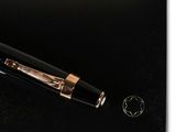 black and gold fountain pen on a black surface next to a gold pen
