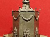 un petit objet métallique posé sur une table avec un fond rouge