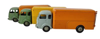 trois camions miniatures alignés les uns à côté des autres sur une surface blanche