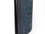 an old book that is sitting on a white surface