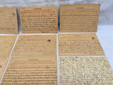 several pieces of old paper with writing on them sitting on a table