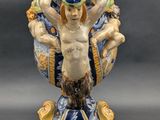 a small vase with a statue on top of it