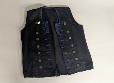 a close up of a black vest with blue buttons on it
