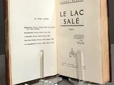 a book open on a table with a glass candle holder