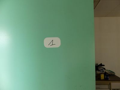 a picture of a room with a green wall and a clock on the wall