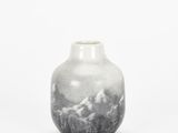 small black and white vase on white background with mountains in the background