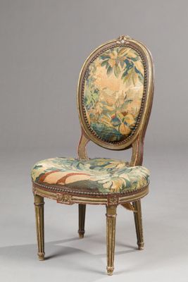 an antique chair with a floral upholstered back and gold legs
