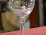 a wine glass sitting on a table with a red table cloth