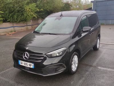 La camionnette noire est garée sur le parking devant un immeuble.