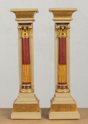 une paire de bougeoirs dorés et rouges posés sur une table en bois
