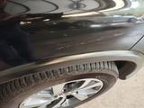 a close up of a car ' s tire with a man standing next to it
