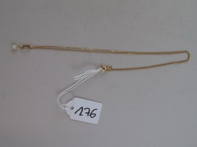 a close up of a tag on a white surface with a chain