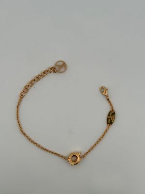 a gold bracelet with a heart charm on it