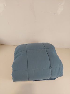 un oreiller bleu posé sur une table blanche