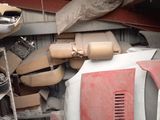 a car that is sitting in a garage with a lot of junk