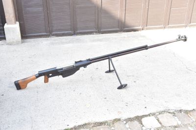 a rifle that is sitting on a stand on the sidewalk