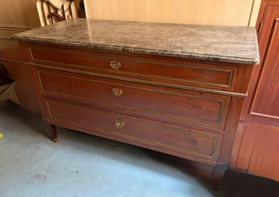 a dresser with a marble top in the corner of a room