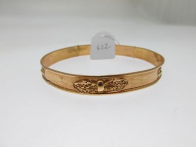 a gold bracelet with a bee on the front of it