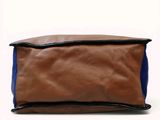 a close up of a brown and blue bag on a white background
