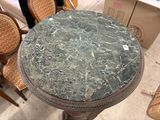 a table with a marble top and chairs in the background