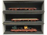 trois petits trains miniatures dans une vitrine, sur fond blanc