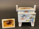a small vase and a small box sitting on a table