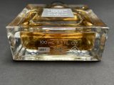 an image of a bottle of perfume sitting on top of a table