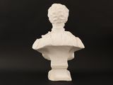 a white busturine of a woman on a pedestal with a black background