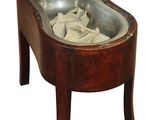 a wooden chair with a wooden seat and a metal bowl on it