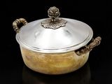 une casserole en argent avec un couvercle, posée sur une surface noire