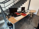 a man standing in front of a desk with a computer on it