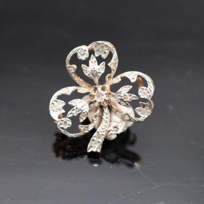 une photo d'une broche en forme de trèfle en or et diamants