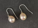 une paire de boucles d'oreilles en perles sur une surface noire