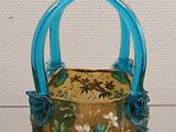 a small blue basket with flowers on it on a table