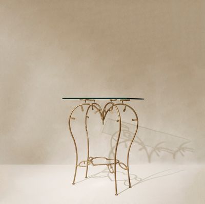 une table avec un plateau en verre posée sur un sol blanc