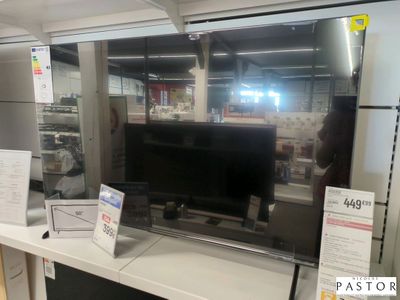 un téléviseur posé sur une table dans un magasin, avec une étiquette de prix