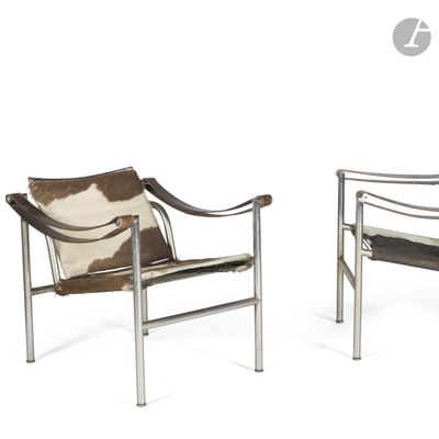 pair of lounge chairs with cow hide and metal frame