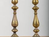 pair of antique brass candlesticks on a wooden table