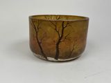 a brown bowl with trees on it on a white surface