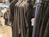 a man that is looking at some clothes on a rack