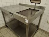 a large stainless steel table in the middle of a tiled room