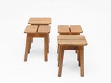 two small wooden stools sitting next to each other on a white surface
